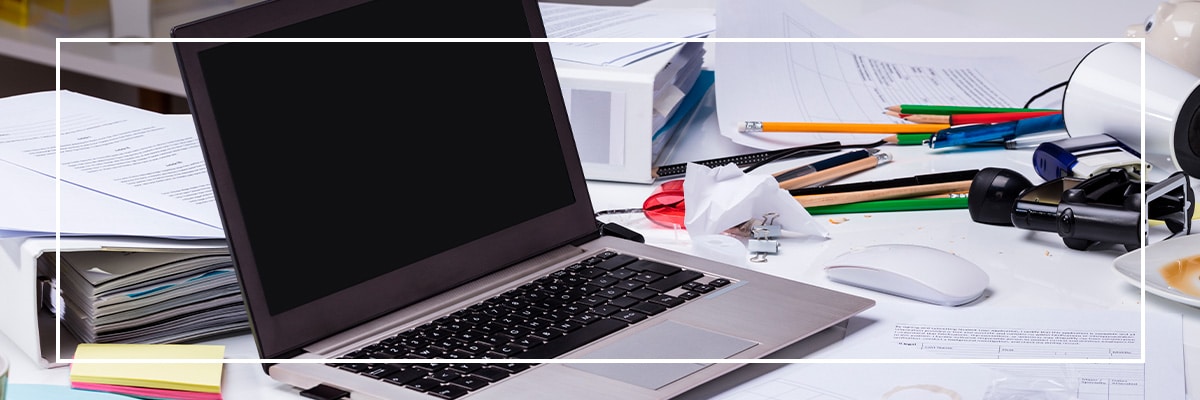 notebook em cima de uma mesa de escritório extremamente bagunçada